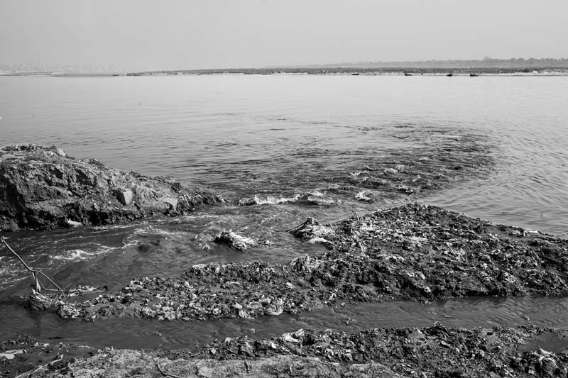 Challenges Impacting the Connection between Water and Religion - River Asi draining untreated wastewater into river Ganga in Varanasi, Uttar Pradesh